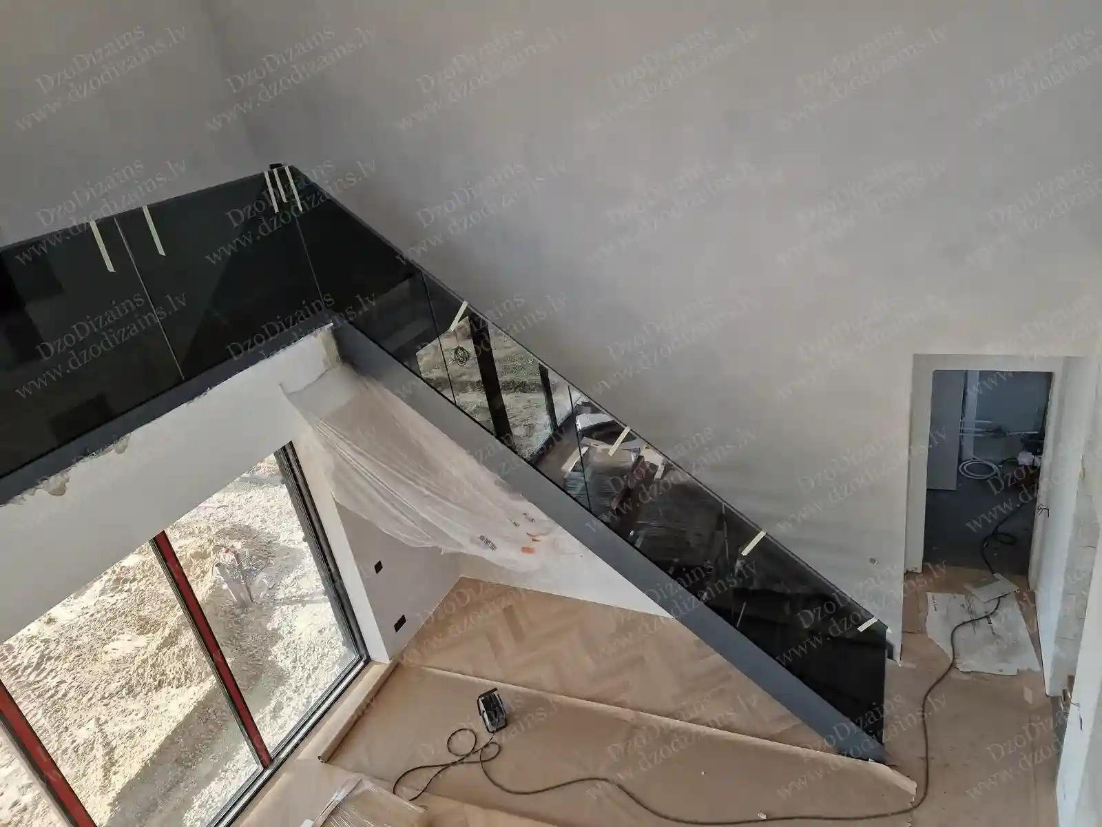 Внутренняя Г-образная лестница со стеклянными перилами и открытым видом на гостиную