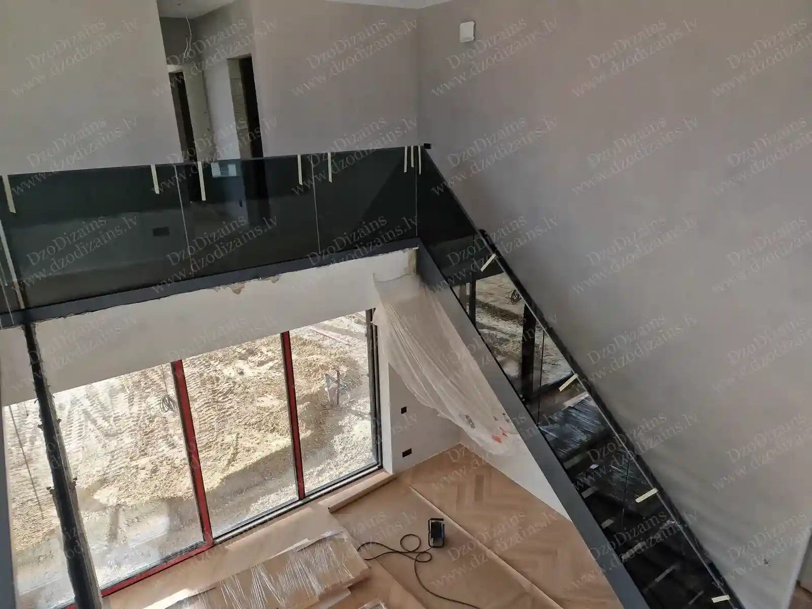 Современная Г-образная лестница со стеклянными боковыми стенками и чёрной металлической конструкцией