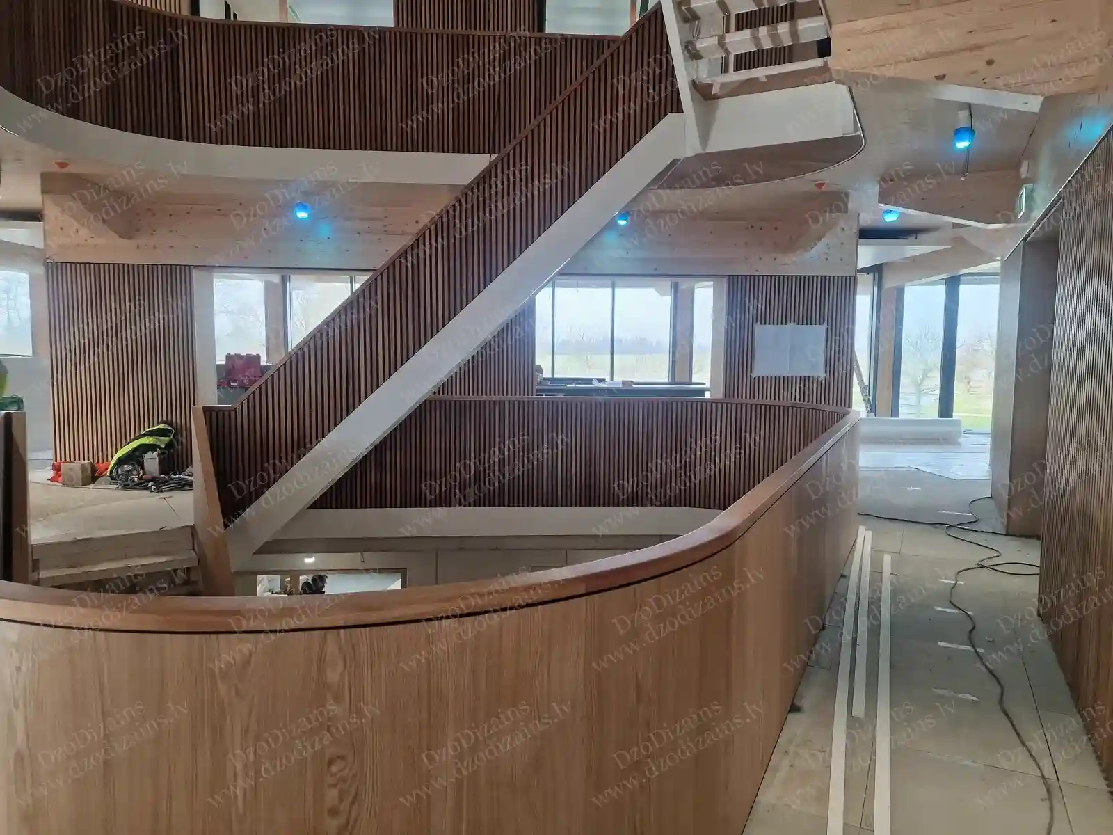 Большая внутренняя деревянная лестница со сложной геометрией и деревянными панелями