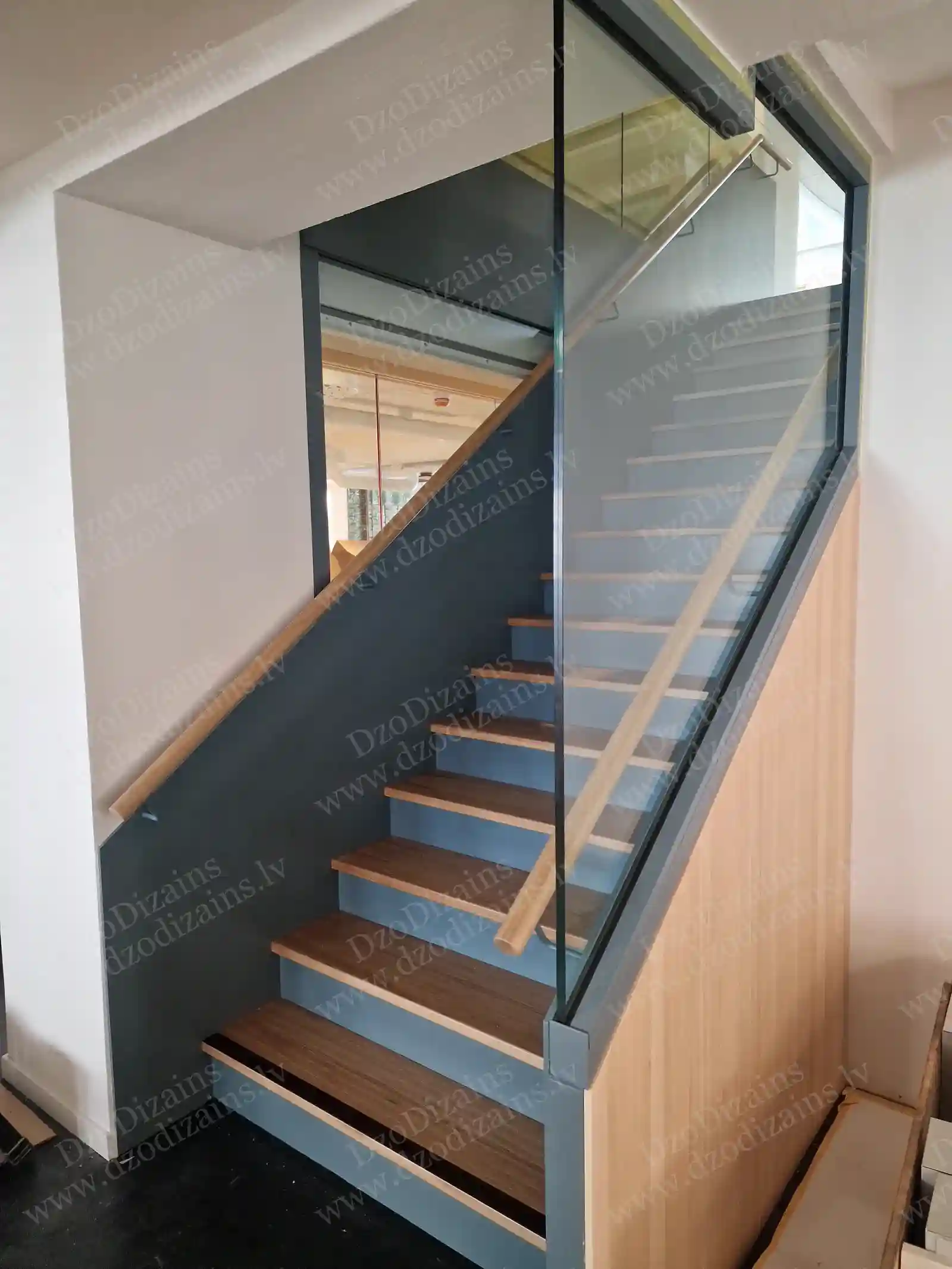 Современная прямая лестница со стеклянными перилами и деревянным поручнем