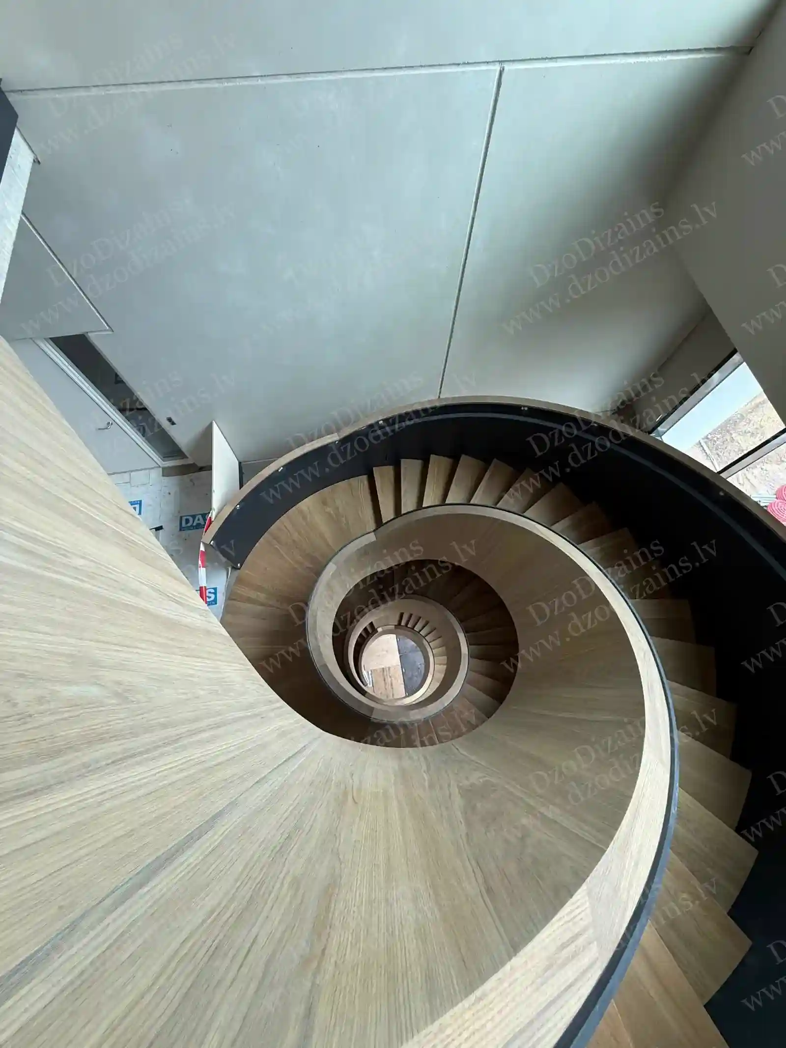 Элегантная винтовая деревянная лестница с деревянными ступенями и тёмной центральной опорой