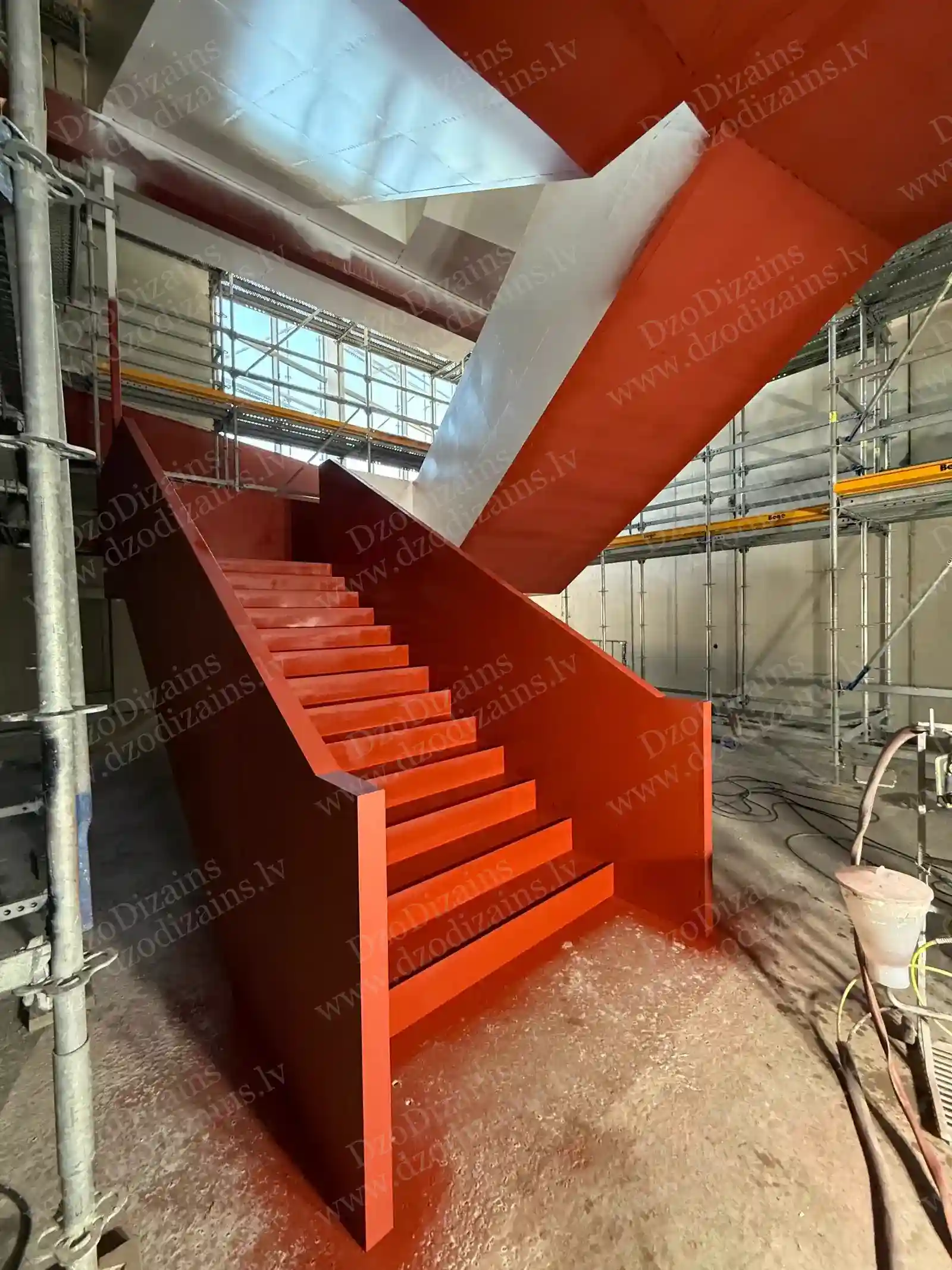 П-образная лестница с ярко-красной отделкой на этапе строительства