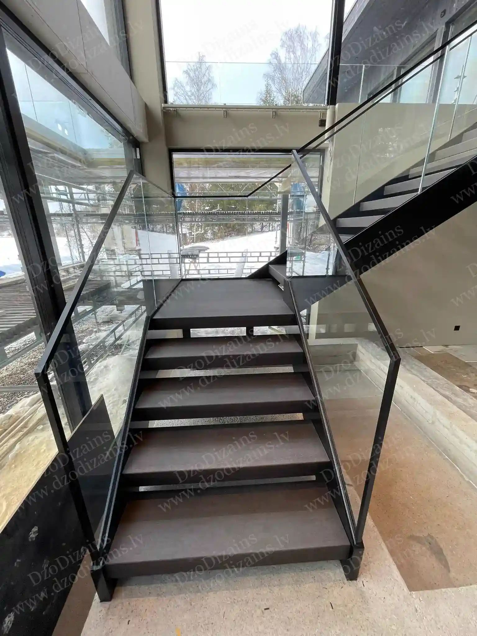 Элегантная Г-образная лестница с тёмной деревянной поверхностью и стеклянными бортами