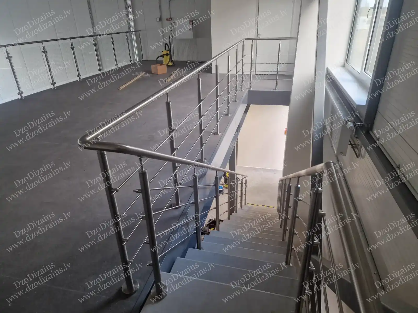 Прямая бетонная лестница с перилами из нержавеющей стали на этапе строительства