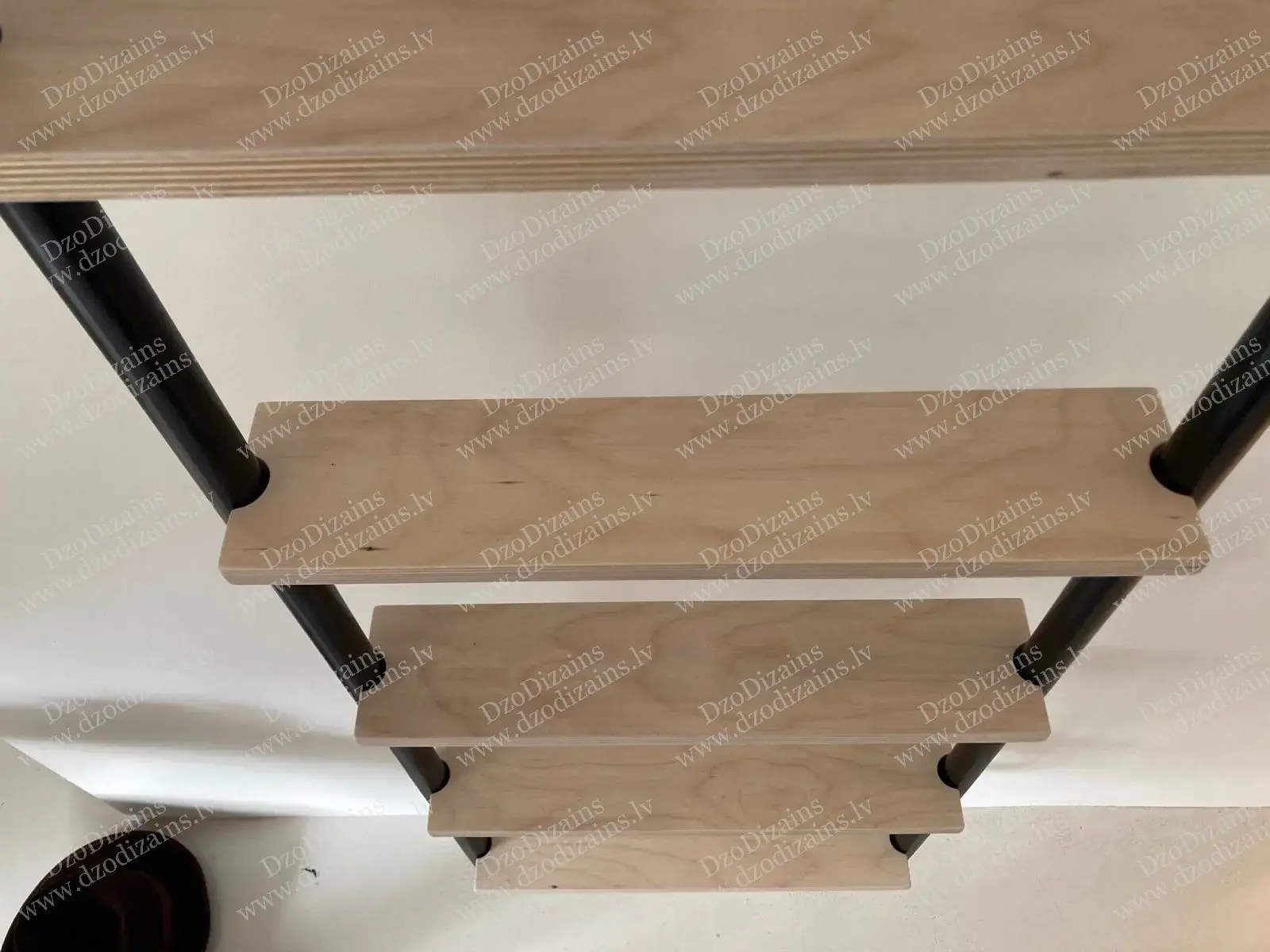 Металлическая лестница к стене со светлыми деревянными ступенями