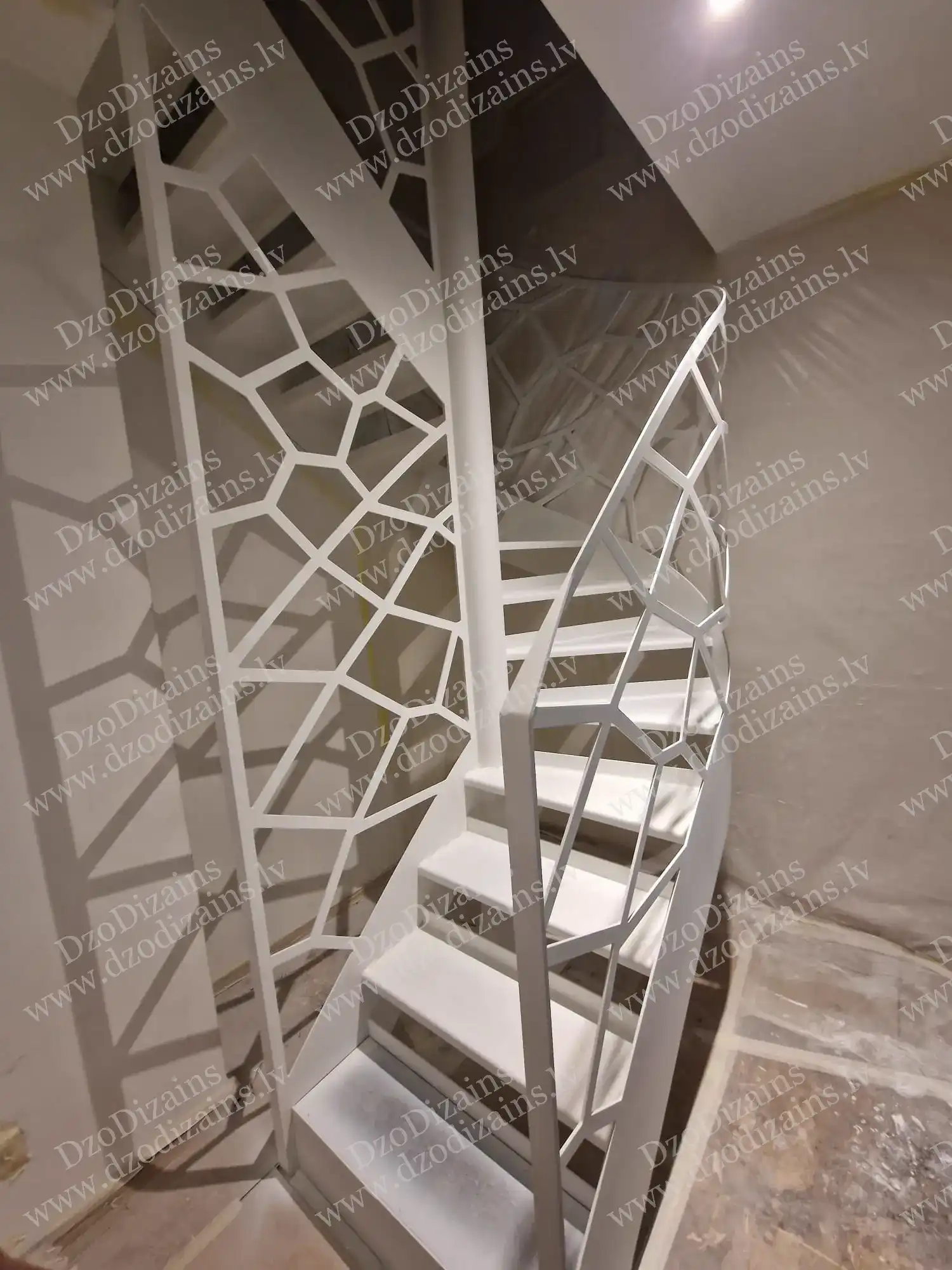 Элегантная винтовая лестница с белыми ступенями и сложным геометрическим дизайном перил
